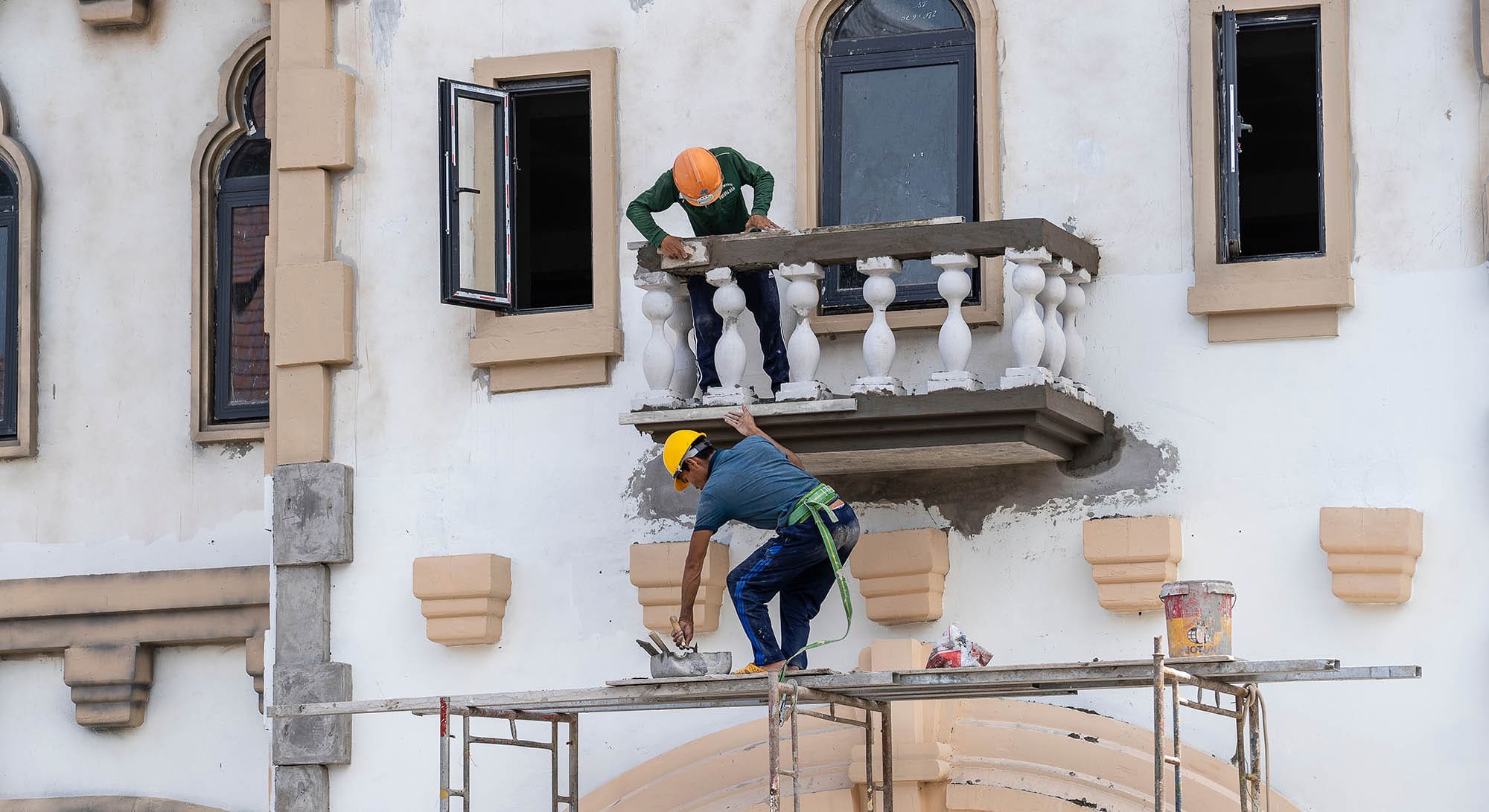 Construction workers repairing a balcony